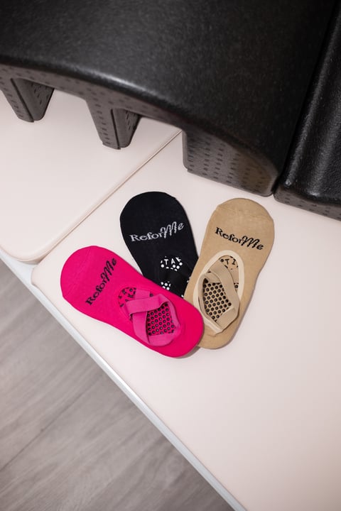 Four colorful no-show socks displaying RestorMe brand name