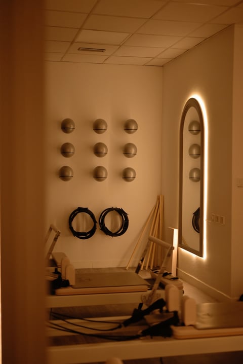 Minimalist fitness room with wall-mounted shelves and neon-outlined mirror