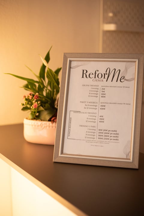Framed ReforMe treatment menu on a shelf with potted plant and warm lighting